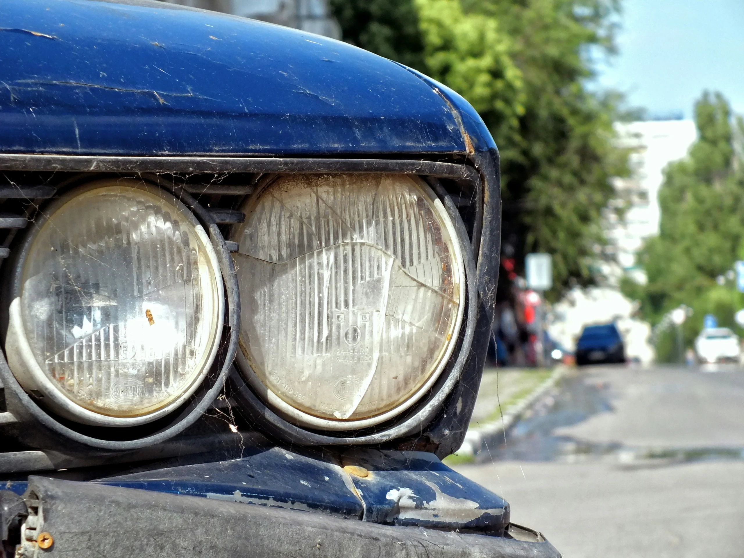 Motorista trocando lâmpada do farol do carro à noite.