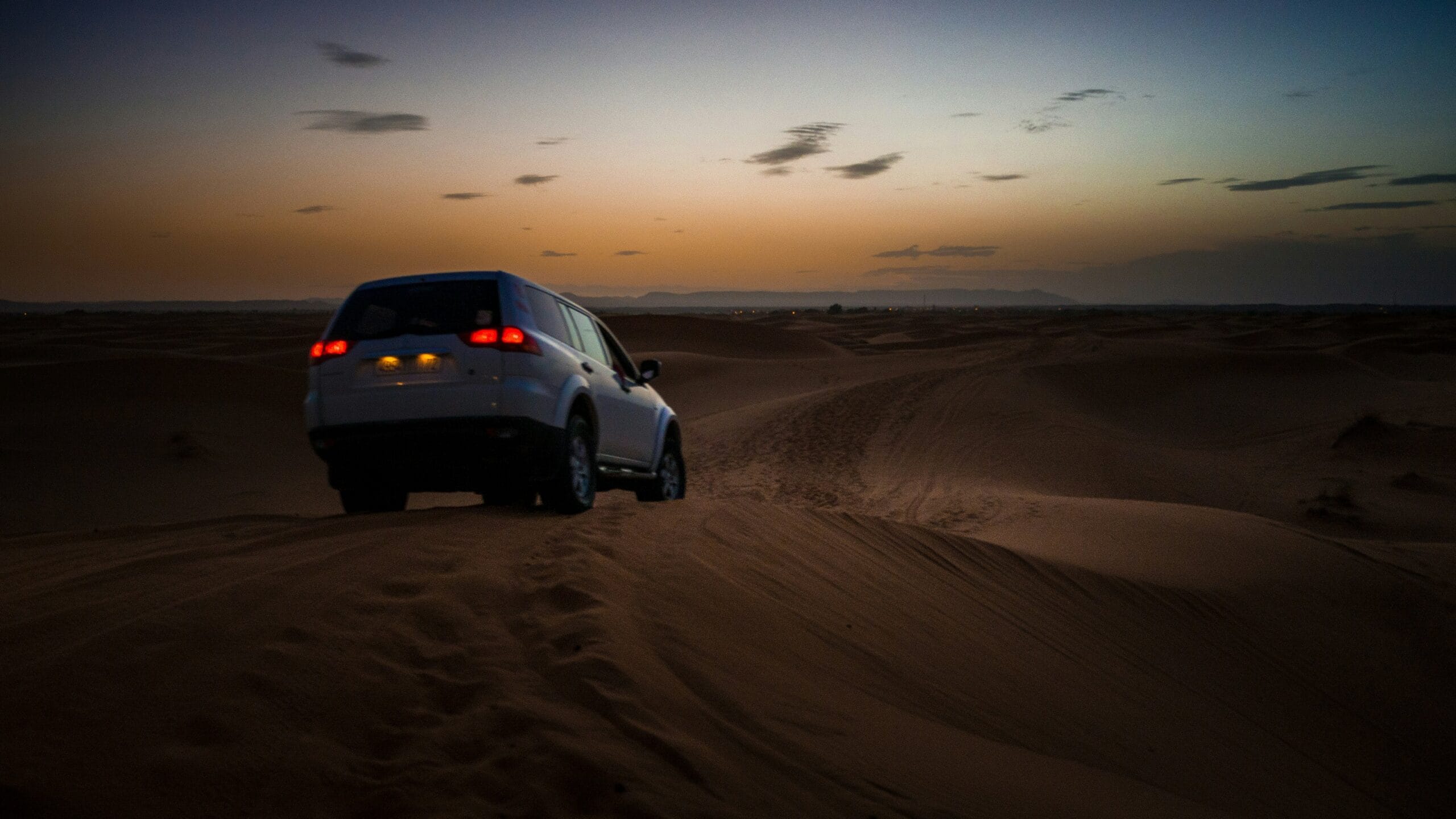 Carro dirigindo em uma estrada de terra no interior.
