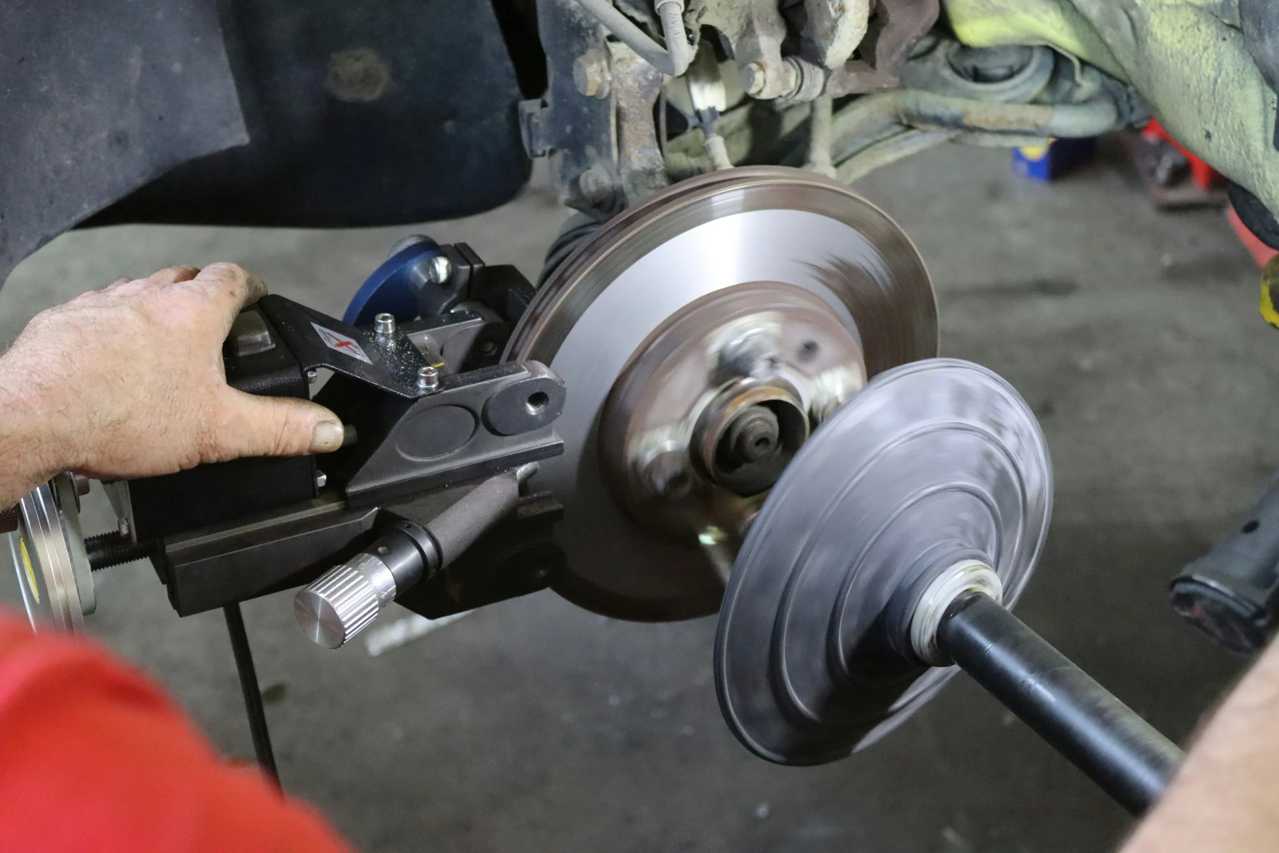 Mecânico verificando sistema de freios do carro com defeito.
